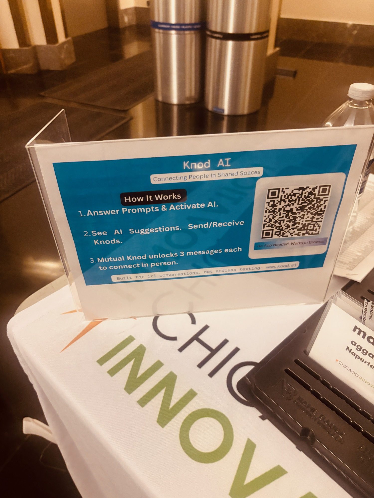 A Knod table card with a QR code on a Chicago Innovation branded table