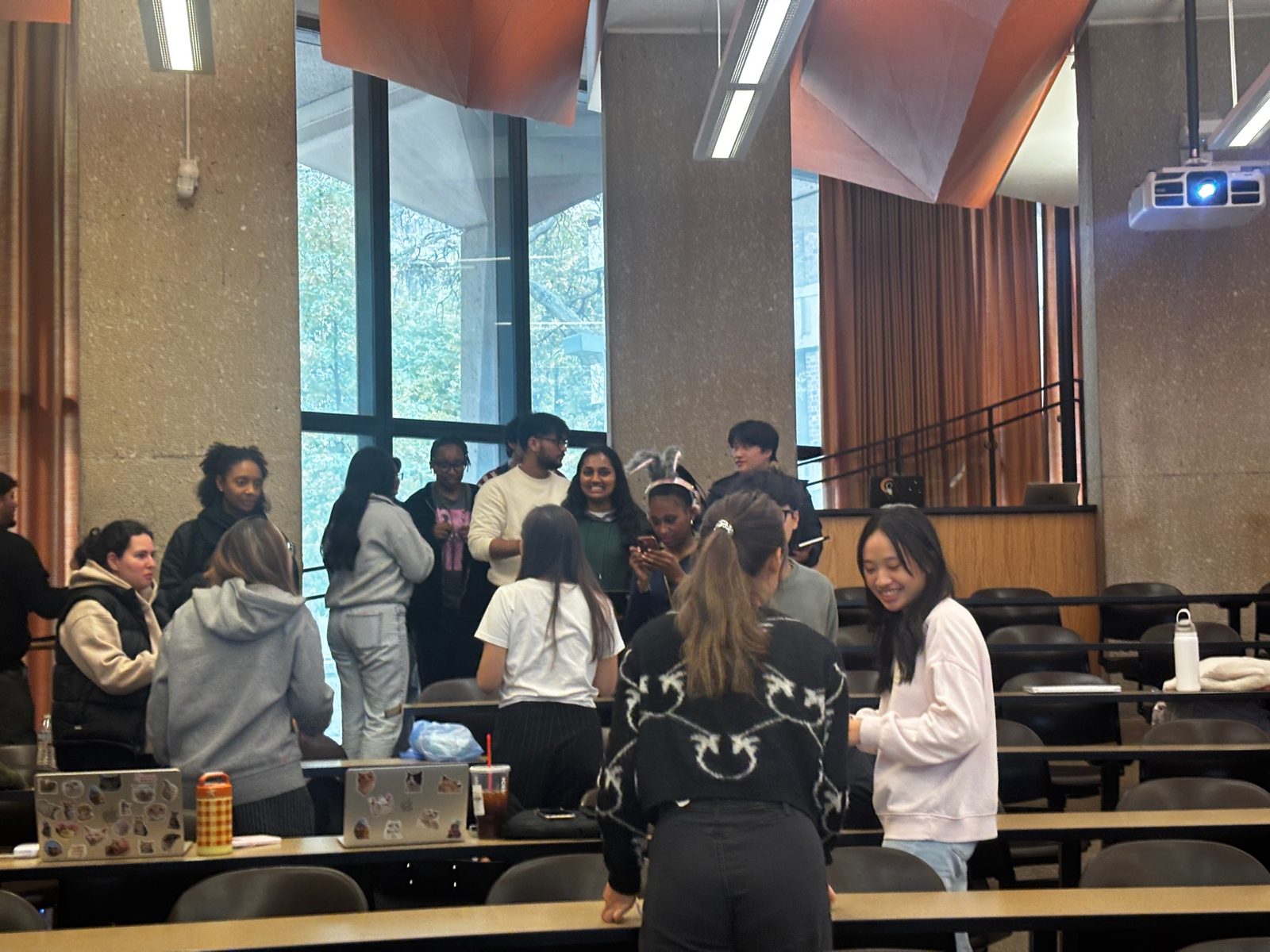 UIC students standing and talking together in a lecture hall